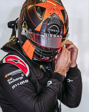 Formula E driver adjusting helmet